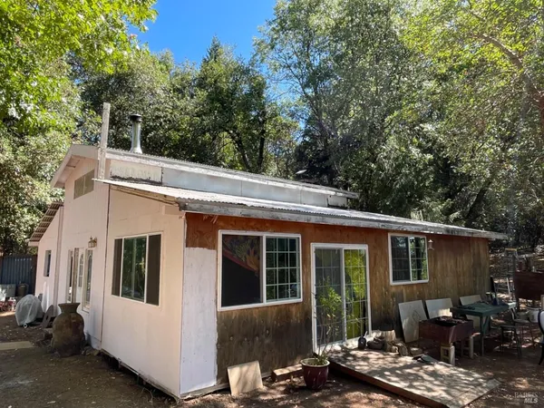 a view of a patio with table and chairs and wooden fence