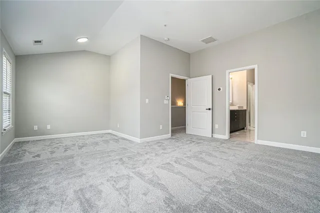 a view of an empty room with closet and a window
