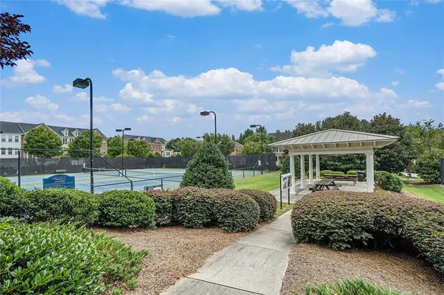 a view of a garden with a slide and table under an umbrella