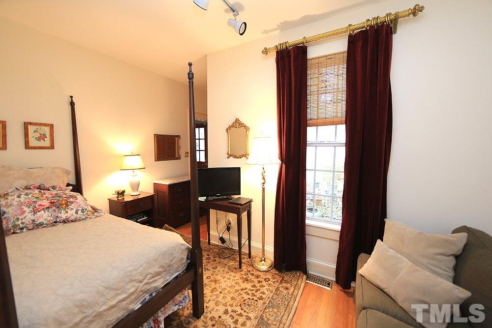 1802 Reaves Drive Raleigh, NC 27608 - Photo 13 of 22 a bedroom with a bed and flat screen tv