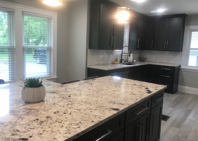4652 South Turner Road Canfield, OH 44406 - Photo 6 of 28 Kitchen featuring sink, light hardwood / wood-style floors, light stone counters, and tasteful backsplash