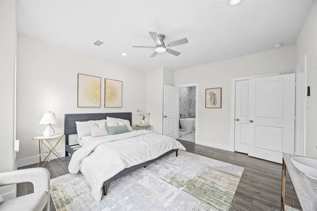 a bedroom with a large bed and a chandelier