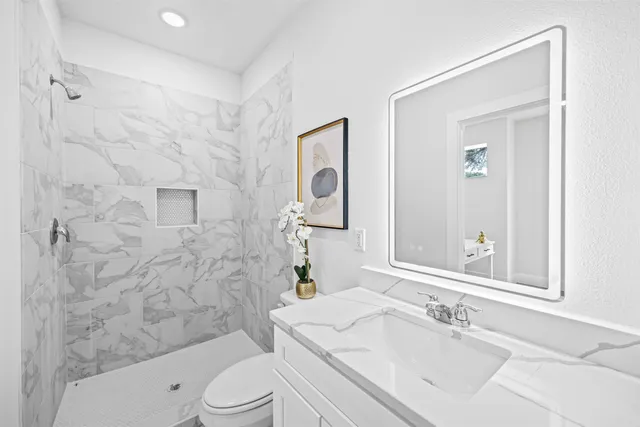 a bathroom with a sink a toilet and shower