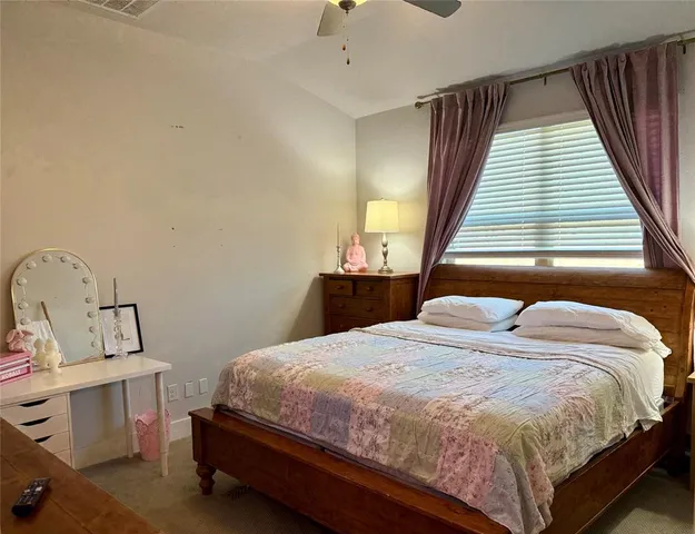 a bedroom with a bed wooden floor and window
