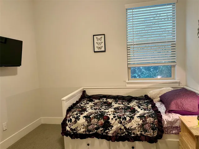 a bed sitting in a bedroom next to a window