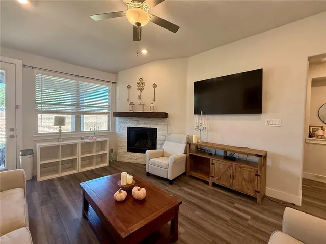 a living room with furniture a flat screen tv and a fireplace