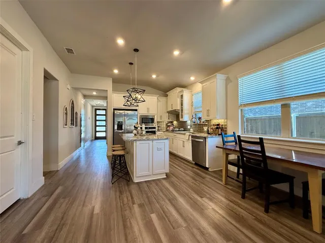 a kitchen with a sink and wooden floor