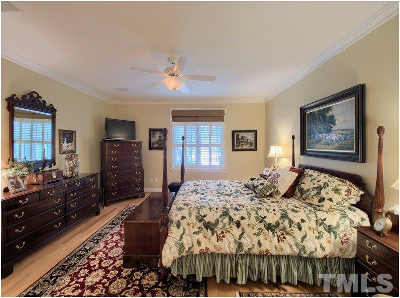 9012 Carrington Ridge Drive Raleigh, NC 27615 - Photo 13 of 22 a bedroom with a bed and dresser with mirror
