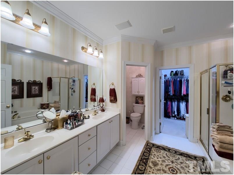 9012 Carrington Ridge Drive Raleigh, NC 27615 - Photo 14 of 22 a bathroom with a double vanity sink a mirror and shower