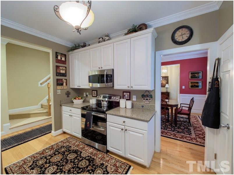 9012 Carrington Ridge Drive Raleigh, NC 27615 - Photo 8 of 22 a kitchen with stainless steel appliances granite countertop a stove top oven a sink a dining table and chairs