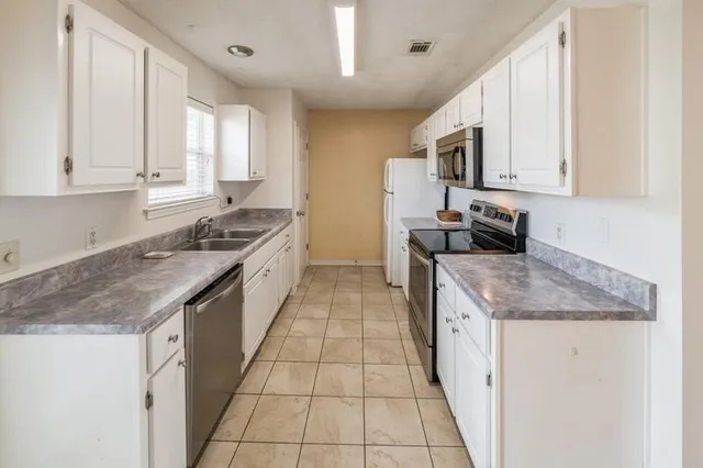 a kitchen with stainless steel appliances granite countertop a sink stove and cabinets