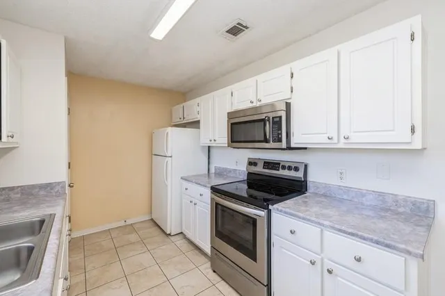 a kitchen with white cabinets and stainless steel appliances