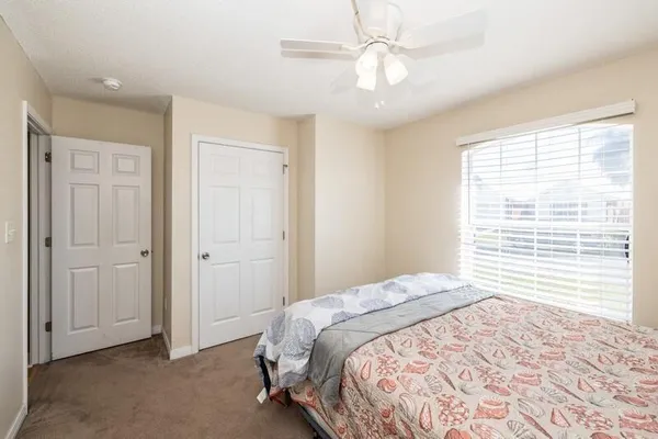 a view of a bedroom with a large bed and a chandelier fan