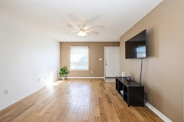a view of a livingroom with wooden floor and a flat screen tv