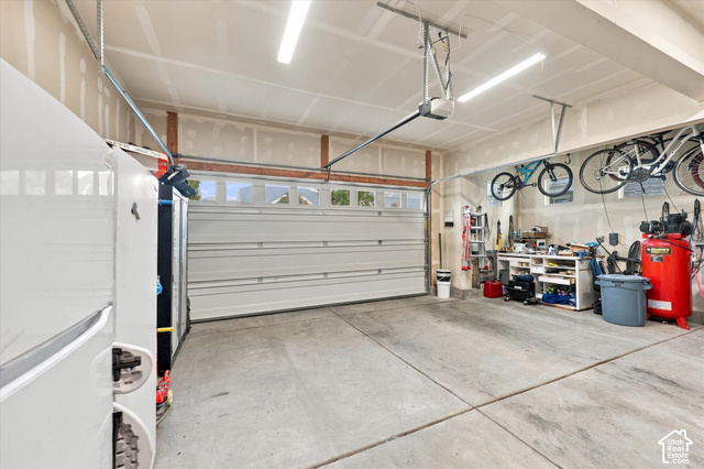 972 Vine Street Mapleton, UT 84664 - Photo 34 of 40 Spacious garage with concrete flooring, automatic garage door opener, overhead fluorescent lighting, and built-in shelving