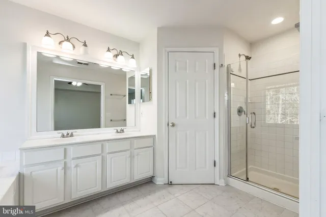 a bathroom with a double vanity sink mirror and shower