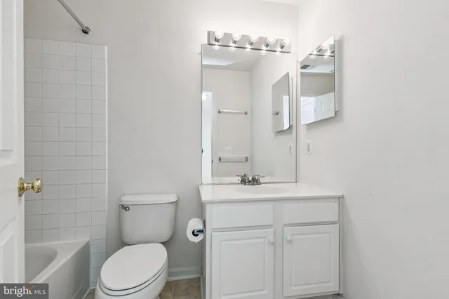 a bathroom with a sink a toilet a mirror and shower