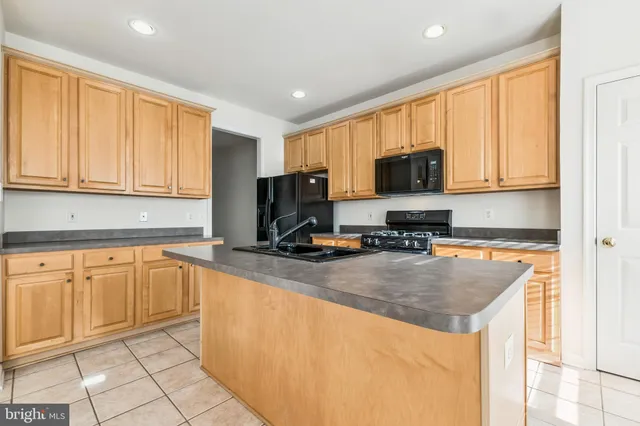 a kitchen with stainless steel appliances granite countertop a stove a sink a microwave and refrigerator