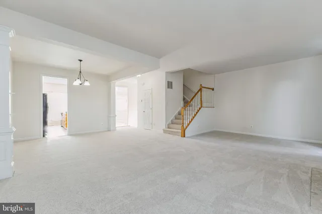 an empty room with staircase and white walls