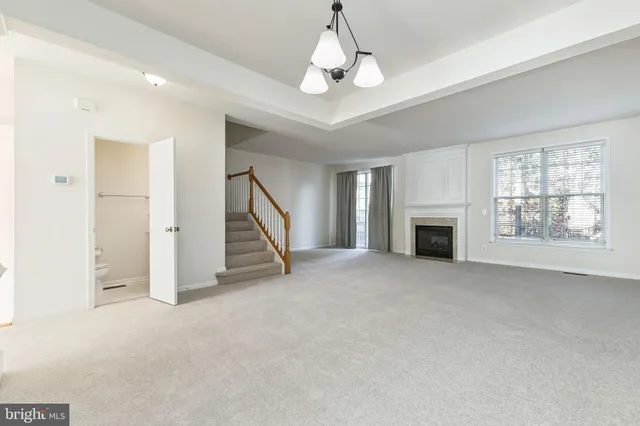 a view of an empty room with a fireplace and a window