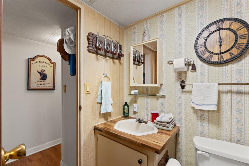 7154 County Road 651 Bushnell, FL 33513 - Photo 17 of 34 a bathroom with a sink vanity mirror and toilet