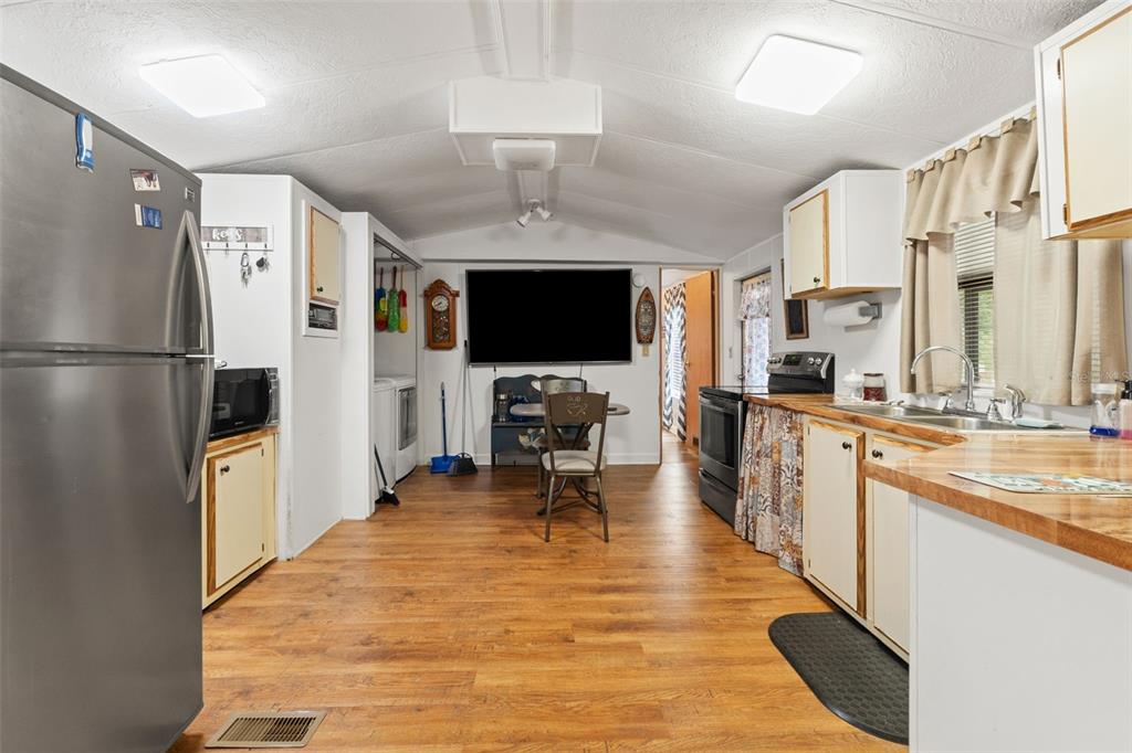 7154 County Road 651 Bushnell, FL 33513 - Photo 8 of 34 a large white kitchen with cabinets a sink and a refrigerator