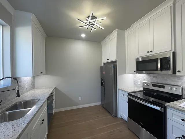a kitchen with stainless steel appliances granite countertop a sink stove and refrigerator