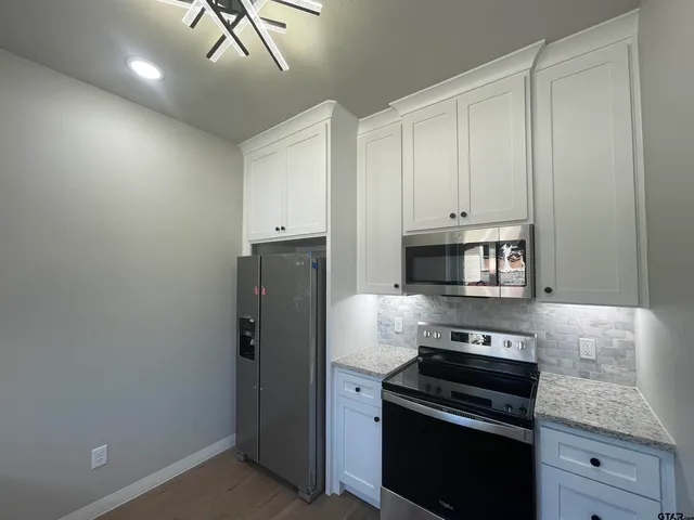 a kitchen with cabinets and steel appliances