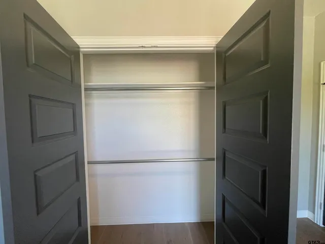 a view of walk in closet with empty racks