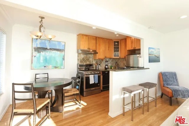 a dining room with a table chairs and a kitchen view
