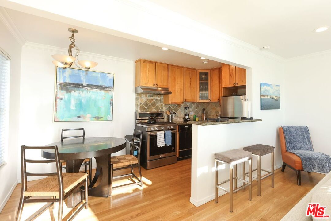 2101 Ocean Avenue, Unit 1 Santa Monica, CA 90405 - Photo 7 of 11 a dining room with a table chairs and a kitchen view