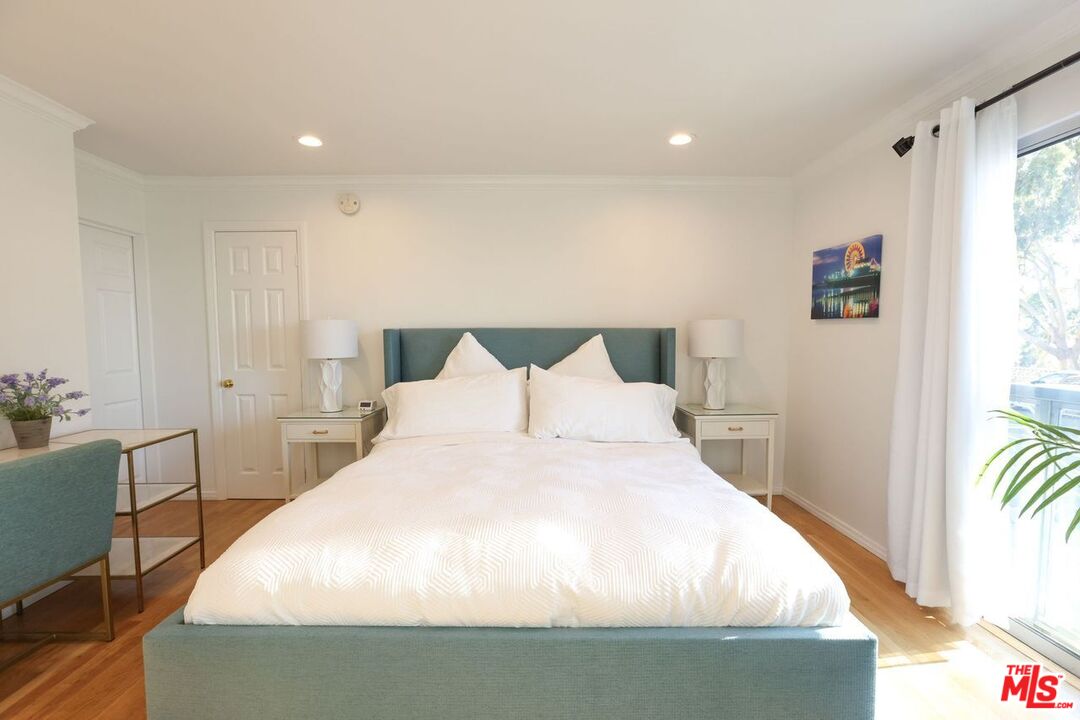 2101 Ocean Avenue, Unit 1 Santa Monica, CA 90405 - Photo 9 of 11 a large bed sitting in a bedroom next to a window with a chair