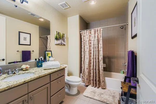 a bathroom with a granite countertop sink toilet and shower