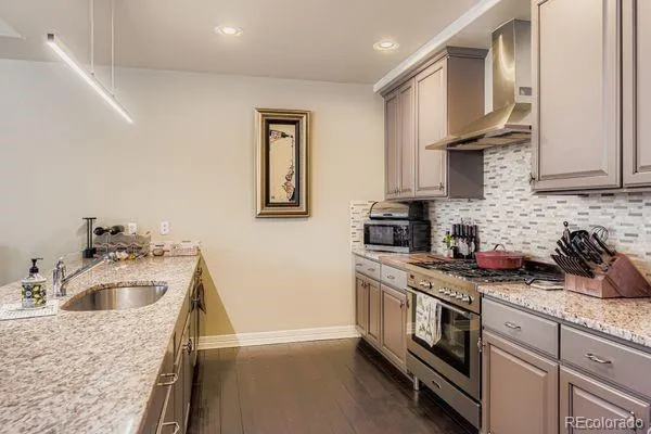 a kitchen with granite countertop white cabinets and a stove