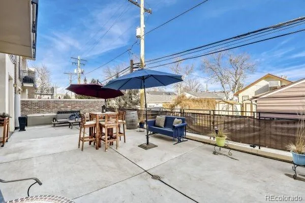 a view of a patio with a table and chairs under an umbrella
