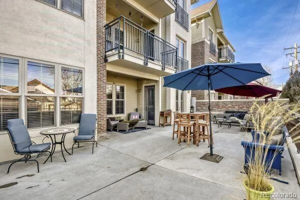 a view of a dinning tables and chairs in the patio in front of a building