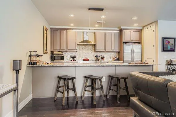 a kitchen with stainless steel appliances granite countertop a table chairs sink refrigerator and cabinets