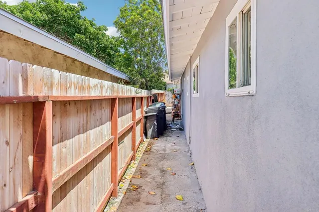 a view of kitchen with stainless steel appliances granite countertop dining table chairs sink and cabinets