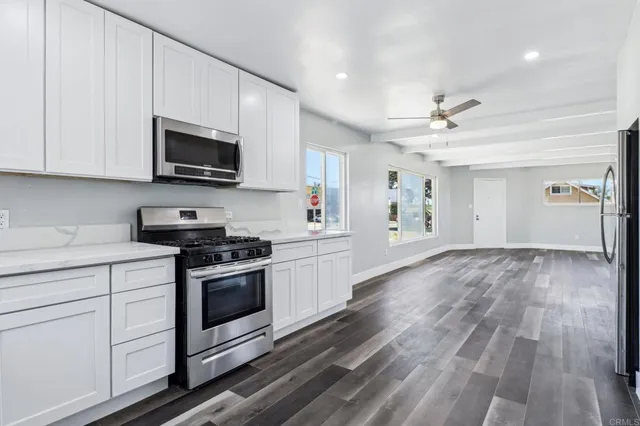 a kitchen with a refrigerator a sink and a stove top oven