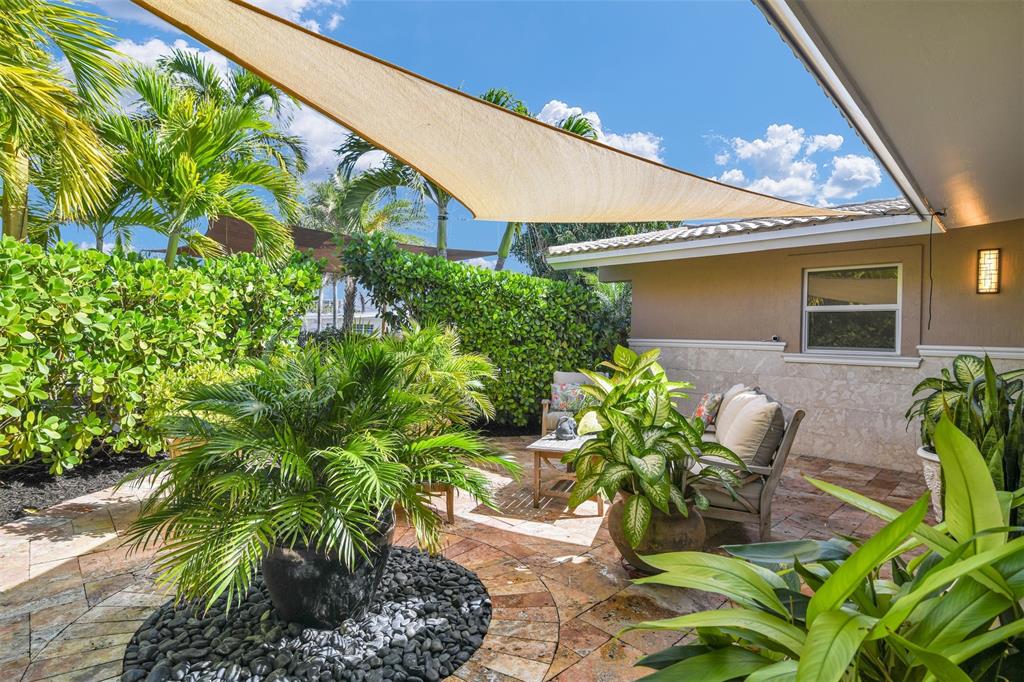 1616 Southeast 4th Street Deerfield Beach, FL 33441 - Photo 15 of 52 a potted plant sitting in front of a blue house with potted plants