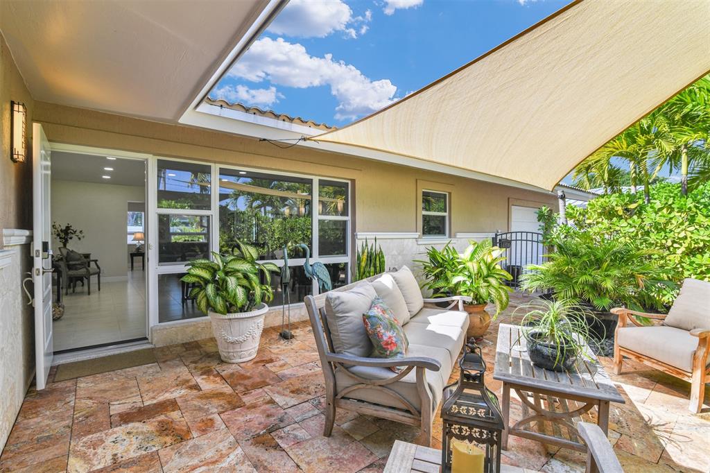 1616 Southeast 4th Street Deerfield Beach, FL 33441 - Photo 19 of 52 a view of a patio with table and chairs potted plants and floor to ceiling window