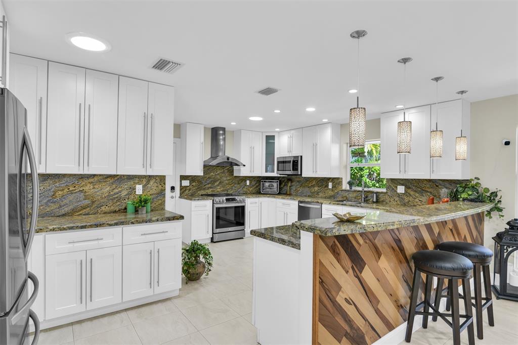 1616 Southeast 4th Street Deerfield Beach, FL 33441 - Photo 24 of 52 a kitchen with white cabinets and stainless steel appliances
