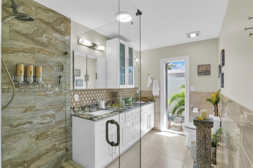 1616 Southeast 4th Street Deerfield Beach, FL 33441 - Photo 35 of 52 a bathroom with a granite countertop sink a mirror and shower