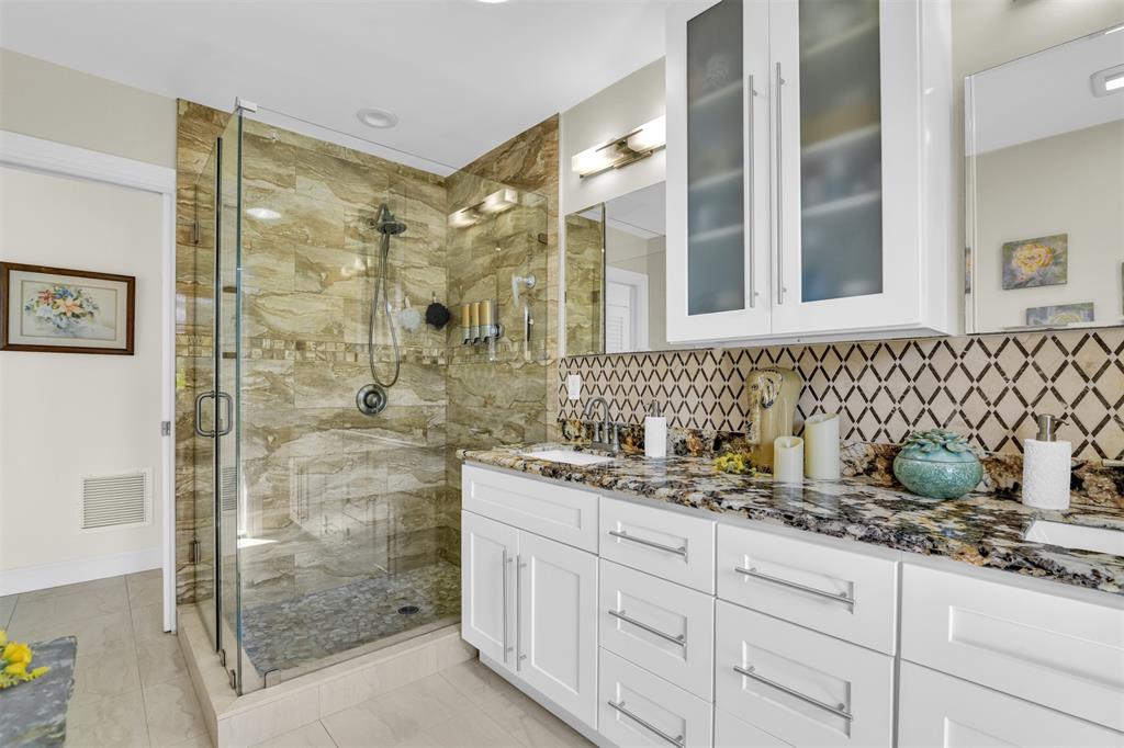 1616 Southeast 4th Street Deerfield Beach, FL 33441 - Photo 36 of 52 a bathroom with a granite countertop sink a mirror a glass door a shower and vanity