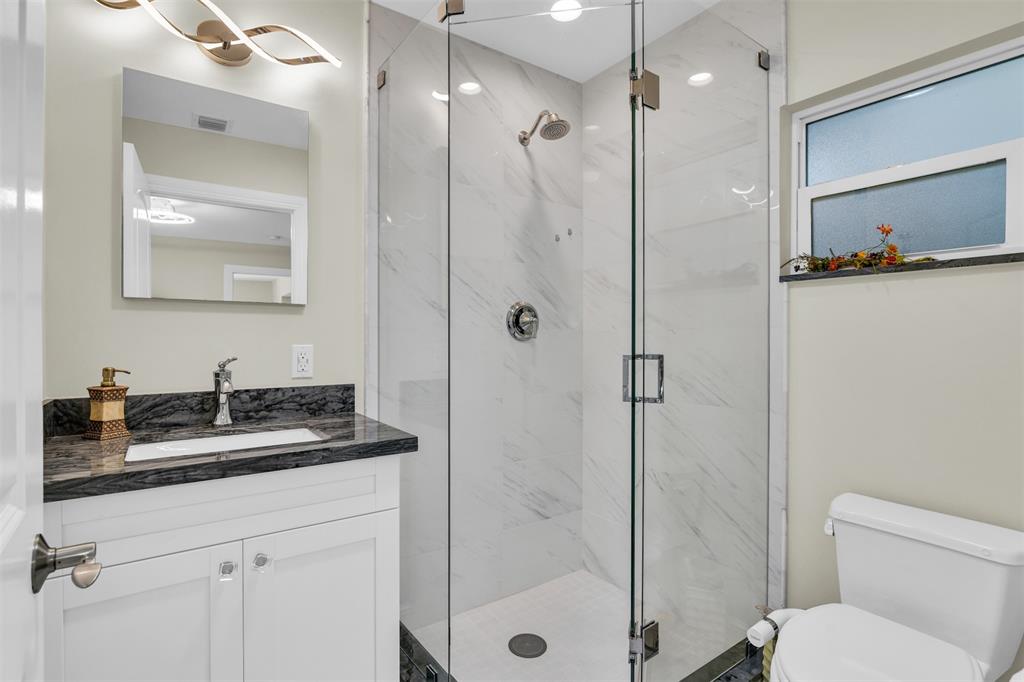 1616 Southeast 4th Street Deerfield Beach, FL 33441 - Photo 44 of 52 a bathroom with a sink vanity granite toilet and shower