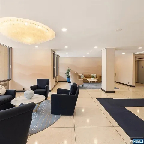 a living room with couches and kitchen view with wooden floor