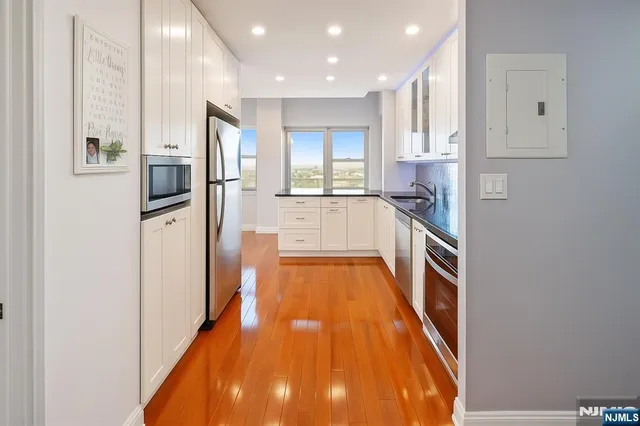 a kitchen with stainless steel appliances granite countertop a refrigerator and a stove