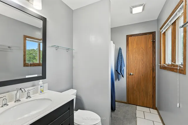 a bathroom with a sink toilet and shower a mirror