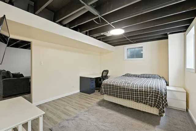 a bedroom with a bed and a refrigerator