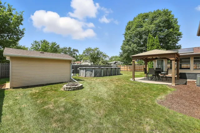 a view of a house with backyard and sitting area